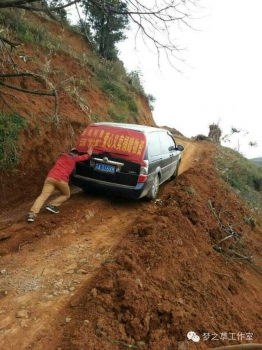  由于地震原因，道路崎嶇，再好的車也要靠人力推才能勉強爬上坡。